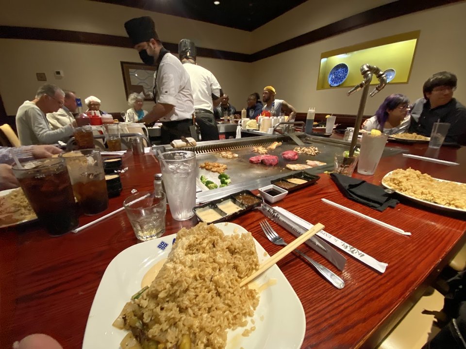 Hibachi grill with plated Japanese steakhouse dishes.